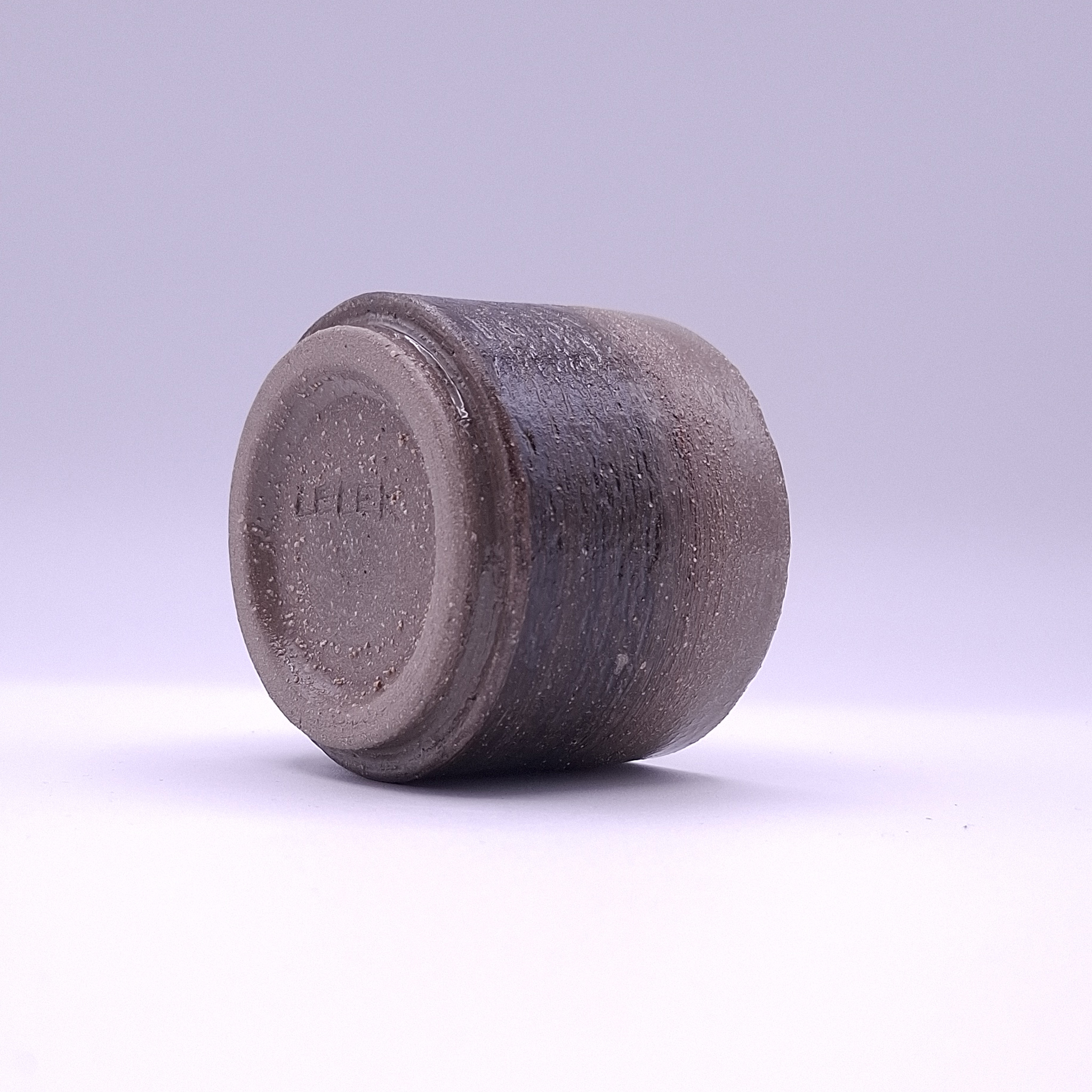 A handbuilt anthracite stoneware cup with white grog and an iron oxide band, shaped by hand in Berlin. One of a kind.